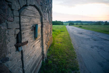 A beautiful summer morning scenery of countryside with an asphalt road. Summertime scenery of Northern Europe.の写真素材