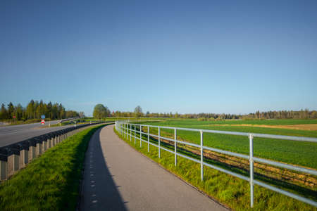Beautiful spring landscape of rural area with asphalt road. Seasonal scenery of Northern Europe.