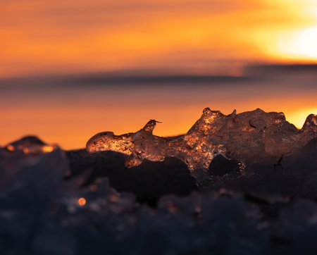 Gilded Winter: Translucent Ice Awakens in Golden Sunrise in Northern Europeの写真素材