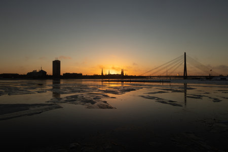 A beautiful winter sunrise landscape in Latvia capital Riga with frozen river Daugava. Colorful cityscape of Northern Europe.の写真素材