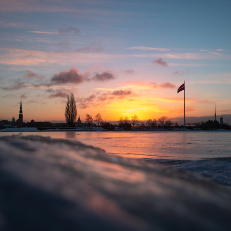 A beautiful winter sunrise landscape in Latvia capital Riga with frozen river Daugava. Colorful cityscape of Northern Europe.の写真素材