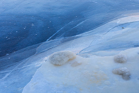 A beautiful cracked ice patterns on the frozen lake surface during winter in Latva. Cold scenery of...