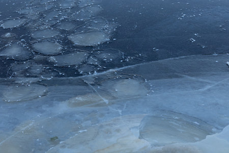 A beautiful cracked ice patterns on the frozen lake surface during winter in Latva. Cold scenery of...