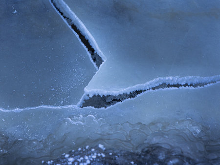 A beautiful cracked ice patterns on the frozen lake surface during winter in Latva. Cold scenery of Northern Europe.の写真素材