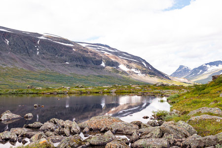 A beautiful small mountain lake in Sarek National Park, Sweden during august. Summer landscape of northern wilderness in Scandinavia.の写真素材