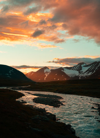 A wild, turbulent mountain river in the Sarek National Park, Sweden. A summer scenery with water in...