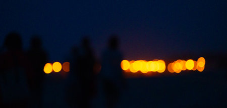 Abstract, blurry bokeh picture of a fire festival at the beach of Baltic Sea. Artistic, colorful scene.の写真素材