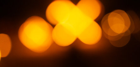 Abstract, blurry bokeh picture of a fire festival at the beach of Baltic Sea. Artistic, colorful scene.の写真素材