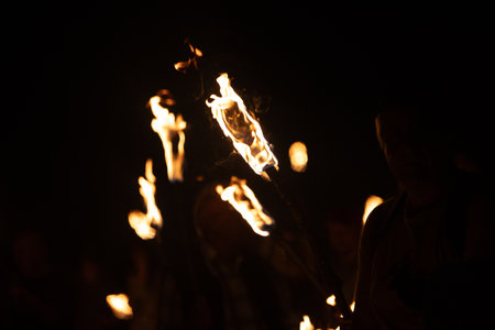 A beautiful close-up of a burning torch with fire flames during the summer festival. Bright fire in the night.の写真素材