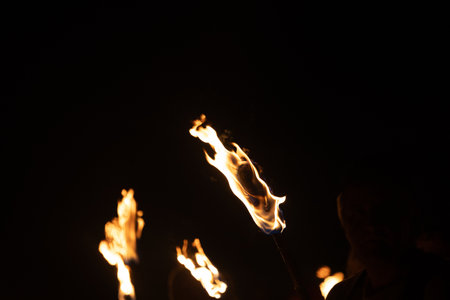A beautiful close-up of a burning torch with fire flames during the summer festival. Bright fire in the night.の写真素材