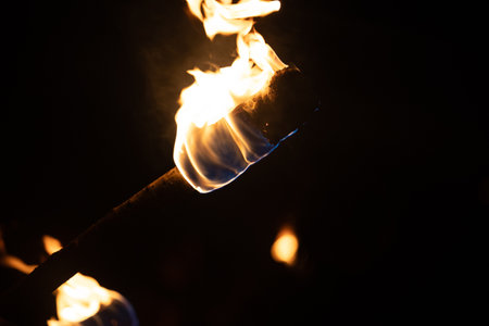 A beautiful close-up of a burning torch with fire flames during the summer festival. Bright fire in the night.の写真素材