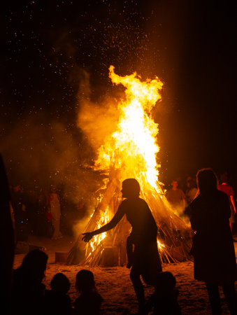 People watching the fire burn on the beach of Baltic sea during Fire Festival in summer. Bright, hot fire.の写真素材