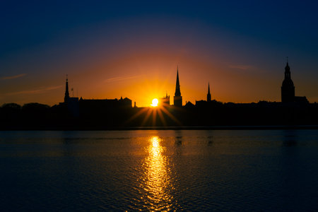 A beautiful Riga cityscape during colorful sunrise. Buildings against colorful sky. Norther Europe morning with warm sky.の写真素材