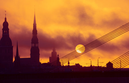 A beautiful citiscape of Riga, Latvia during sunrise. Church towers against colorful sky. City panorama in morning with buildings.の写真素材