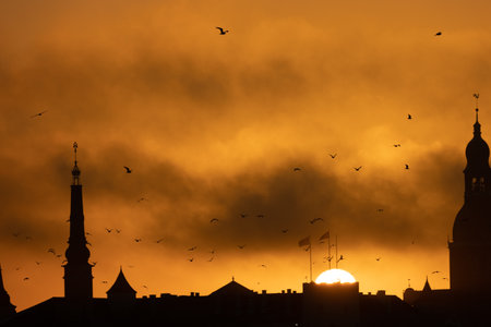 A beautiful Riga cityscape during colorful sunrise. Buildings against colorful sky. Norther Europe morning with warm sky.の写真素材