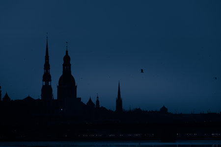 A beautiful citiscape of Riga, Latvia during sunrise. Church towers against colorful sky. City panorama in morning with buildings.の写真素材