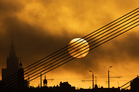 A beautiful Riga cityscape with suspension bridge over the riwer during colorful sunrise. Buildings against colorful sky. Norther Europe morning with warm sky.の写真素材