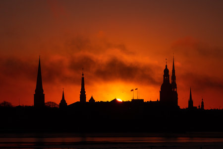 A beautiful citiscape of Riga, Latvia during sunrise. Church towers against colorful sky. City panorama in morning with buildings.の写真素材