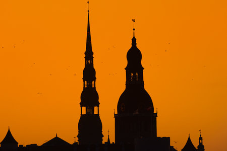 A beautiful Riga cityscape during colorful sunrise. Buildings against colorful sky. Norther Europe morning with warm sky.の写真素材