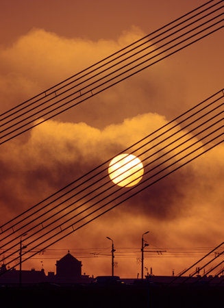 A beautiful Riga cityscape with suspension bridge over the riwer during colorful sunrise. Buildings against colorful sky. Norther Europe morning with warm sky.の写真素材