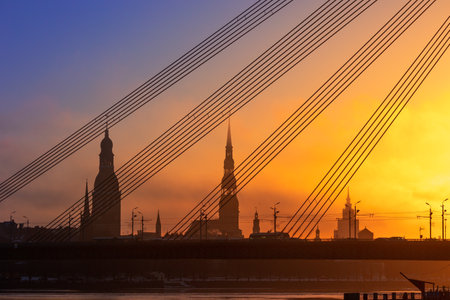 A beautiful citiscape of Riga, Latvia during sunrise. Church towers against colorful sky. City panorama in morning with buildings.の写真素材