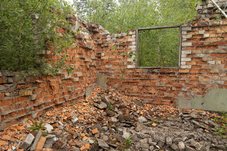 An old, collapsed building of Soviet army base in Latvie, Europe. Red brick wall of abandoned house.の写真素材