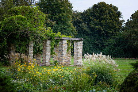A beautiful park landscape with a stone brick pavilion and blooming plants. Autumn scenery of Nordpark, Dusseldorf, Germany.の写真素材