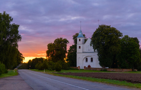 A beautiful summer sunrise in rural Latvia. Bright morning sky with dark foreground.の写真素材