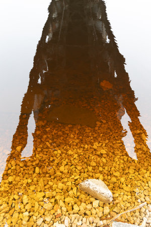 A beautiful springtime scene under the old metal railway bridge over the river. Metal construction from below.の写真素材