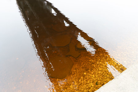 A beautiful springtime scene under the old metal railway bridge over the river. Metal construction from below.の写真素材