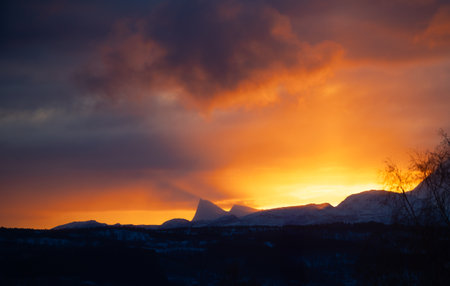 Beautiful, colorful winter sunrise skies over the snowy mountains and fjords in Norway during polar...