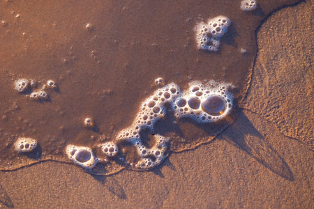 Beautiful sand and water patterns on a sunny beach of Baltic Sea.