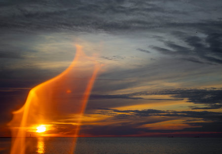 An artistic sunset svenery with sun flares at the beach of Baltic Sea. Summer evening in Latvia,...