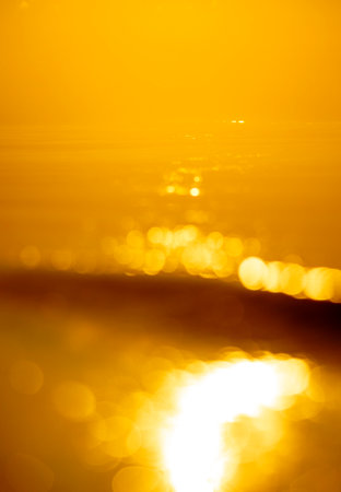 A abstract out of focus sunset picture with a setting sun reflecting in the waves of Baltic Sea. Colorful bokeh.の写真素材