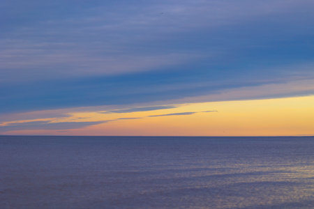 A minimalist landscape of a summer sunset at the beach of Baltic Sea. Colorful scenery in Latvia, Europe.の写真素材