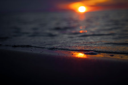 A beautiful shallow depth of field protograph of sunset sunrays reflecting in the beach sand. Summer...