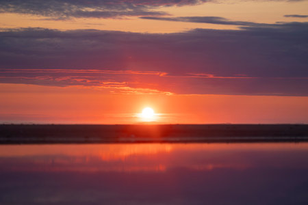 A beautiful pink sunrise over the Baltic Sea. Summer morning at the beach. Latvia, Europe.の写真素材