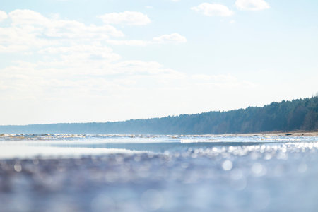 A beautiful sunlit waves crashing on the beach of Baltic Sea. Sunny summer day in Latvia, Europe.の写真素材