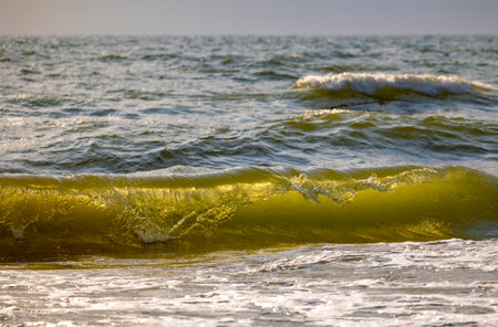 A beautiful sunlit waves crashing on the beach of Baltic Sea. Sunny summer day in Latvia, Europe.の写真素材