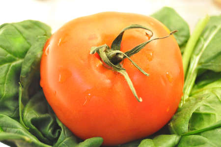 details close up of green spinach and a red tomato の写真素材