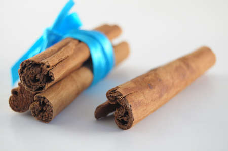 Cinnamon Sticks woth blue ribbon on white backgroundの写真素材