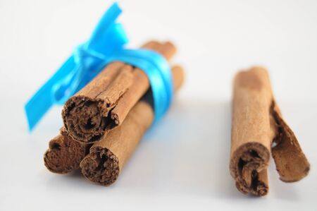 Cinnamon Sticks woth blue ribbon on white backgroundの写真素材