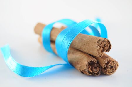 Cinnamon Sticks woth blue ribbon on white backgroundの写真素材