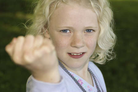 Young blond girl showing her fistの写真素材