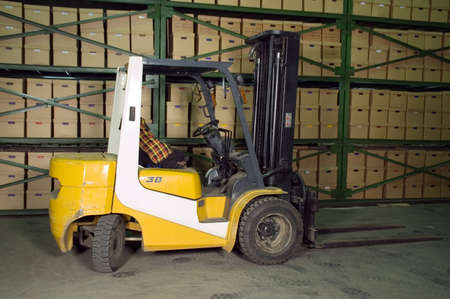 Truck in the warehouse. Boxes on the shelves in the background.