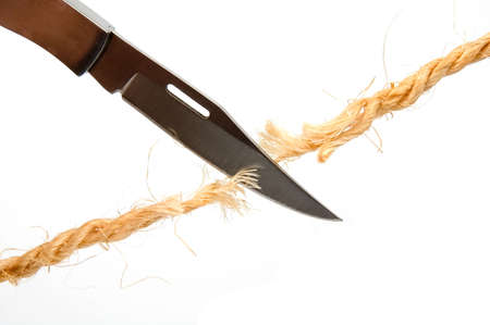 The clasp-knife is cutting the ropes fibers isolated over whiteの写真素材