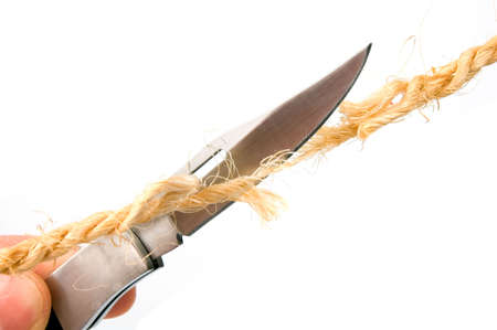The clasp-knife is cutting the ropes fibers isolated over whiteの写真素材