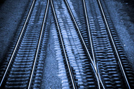 Three crossing railway tracks in cold blue tonesの写真素材