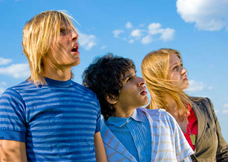 Three very surprised friends look at something in the sky (may be UFO?)の写真素材