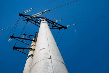 High voltage electric pillar against blue skyの写真素材